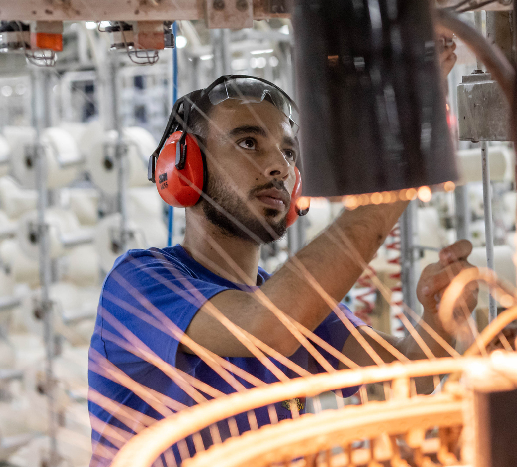A man wearing ear defenders on the Fruit of the Loom production line.